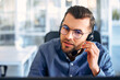 © Valerii Apetroaiei - A call center worker sitting at a laptop in the office.