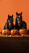 Portrait of two horses with halloween pumpkins on orange background