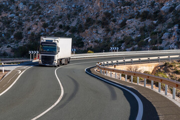 Wall Mural - Truck with a refrigerated semi-trailer driving on a winding mountain road