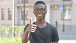 © stockbakers - Outdoor Portrait of Young African Man Doing Thumbs Up