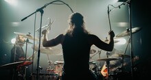 Man On A Stage Performing On The Drums During A Concert, Shot From Back