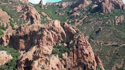 Canvas Print - Landscape drone view of green forested hill with huge rocks and blue seascape on a sunny day