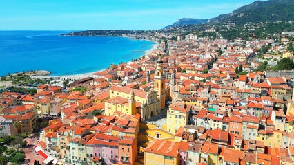 Poster - Aerial shot of a scenic coastal landscape showcasing a picturesque beach and a quaint seaside town.