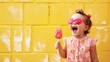 Cute happy baby girl eating ice cream on a stick against a yellow brick wall. Fruit popsicle. Illustration for banner, poster, cover, brochure, advertising, marketing or presentation.