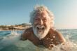 old man with gray hair, grandpa, swimming and splashing in the sea, water, joyful smiling face, happy and fun on vacation. Retirement planning. High quality photo