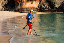 Caucasian Male Using A Metal Detector In The Blue Waters Of Phra Nang Cave Beach On The Railay Peninsula In The Province Of Krabi, Thailand