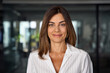 © Stock 4 You - Headshot close up portrait of latin hispanic confident mature good looking middle age leader, ceo female businesswoman on blur office background. Gorgeous beautiful business woman smiling at camera.