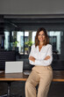 © Stock 4 You - Vertical photo of Hispanic business woman with crossed arms smiling at camera. European or latin confident mature good looking middle age leader female businesswoman on office background, copy space.