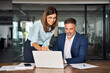 © Stock 4 You - Team of diverse partners mature Latin business man and European business woman discussing project on laptop sitting at table in office. Two colleagues of professional business people working together.