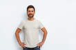 © Daria - Smiling handsome man in stylish t-shirt standing on white background and looking at camera