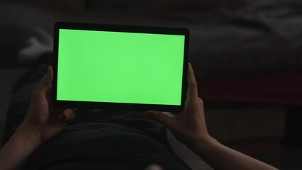 Wall Mural - Man at home lying on a couch with tablet pc with green screen