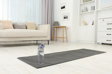 Wall Mural - Yoga mat and bottle of water on floor in room