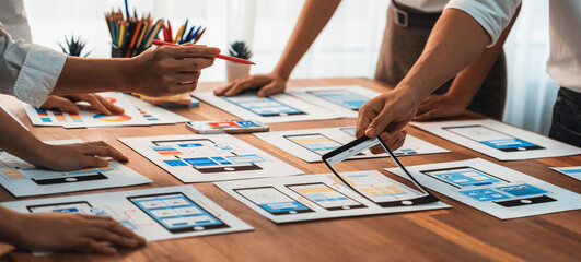Wall Mural - panorama shot of front-end developer team brainstorming ui and ux designs for mobile app on paper wi