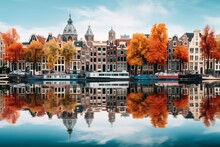 Amsterdam With Its Gabled Houses Mirrored In The Calm Canal, Framed By Trees Showing Their Vibrant Fall Foliage