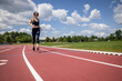 © Cavan Images - fit woman in black running clothes jogs on a track