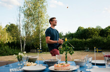 Man Celebrating Swedish Midsummer Popping Champagne In The Garden