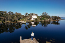 Aerial View Of A Woman Standing On Pier Looking At The Coopers Mill In The Estuary Near Mandurah, Western Australia 