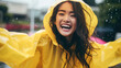 © Sasint - Rainy day Asian woman wearing a raincoat outdoors, happy and funny