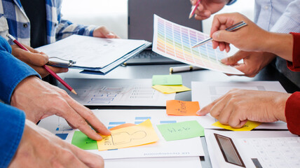 Close-up ux developers and ui designers use augmented reality to brainstorm on mobile app interface wireframe designs on modern office desks. Creative digital development office