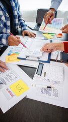 Close-up ux developers and ui designers use augmented reality to brainstorm on mobile app interface wireframe designs on modern office desks. Creative digital development office