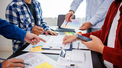 Close-up ux developers and ui designers use augmented reality to brainstorm on mobile app interface wireframe designs on modern office desks. Creative digital development office