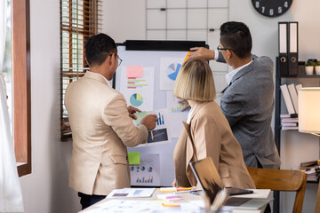 Wall Mural - Group of confident business people point to graphs and charts to analyze market data, balance sheet, account, net profit to plan new sales strategies to increase production capacity.	