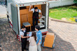 © Kiattisak - Asian Couple check while unloading boxes and furniture from a pickup truck to a new house with service cargo two men movers worker in uniform lifting boxes. concept of Home moving and delivery.