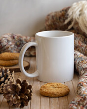 White Coffee Mug On Wooden Table Near Pine Cones, Cookies And Sweater, Winter Mockup