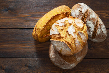 Aufkleber - Stack of different loaves of bread on a wooden table with copy space