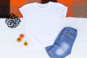 Wall Mural - White kids t-shirt with jean and pumpkins on a white background. Blank halloween t shirt with space your design