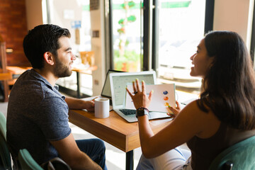 Wall Mural - Young woman and man talking about their freelance work