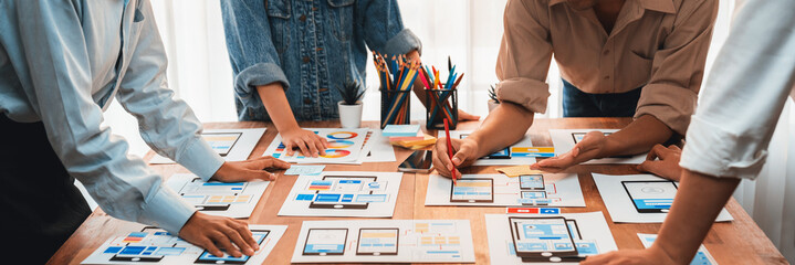 Wall Mural - panorama shot of front-end developer team brainstorming ui and ux designs for mobile app on paper wi