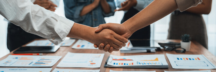 Leinwandbilder - Analyst team celebrates successful data analysis with handshake. Panorama shot handshaking after adjusting attitude or brainstorm for future success in meeting room with BI dashboard paper. Scrutinize