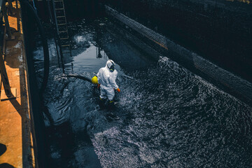 Male worker cleaning sump crude oil surface background