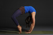 © AkosHorvathWorks - Woman doing yoga in photo studio on isolated grey background.