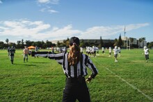 Closeup Of An American Football Referee Standing On The Field Watching The Game.
