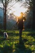 Young woman walking her pet dog on a lush green meadow in a forest setting