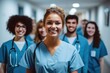 © visoot - Portrait of a young nursing student standing with her team at hospital corridor.