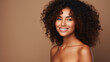 © ckybe - Gorgeous African American woman showcases flawless, radiant skin against a beige backdrop. A captivating smile graces Afro beauty with luscious, curly black hair.