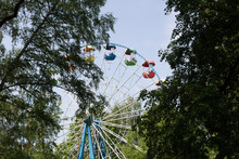 Wheel In The Park. Part Of Ferris Wheel Over Blue Cloudy Sky Background In A Fun Park.