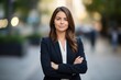 © id512 - young smiling professional business woman, standing outdoor on street arms crossed on blurry background