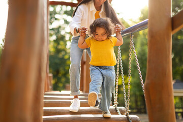 Wall Mural - Asian Mommy With Baby Walking Swinging Bridge At Playground Outdoor