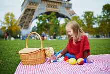 Adorable Preschooler Girl Having Picnic Near The Eiffel Tower In Paris, France