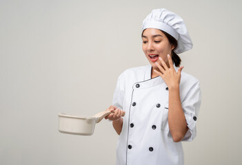 Wall Mural - Young beautiful asian woman chef in uniform holding soup pot ladle utensils cooking in the kitchen various gesture menu good taste on isolated. Cooking woman chef people in kitchen restaurant