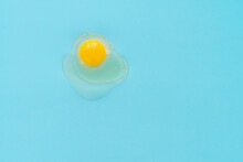 Directly Above View Of Raw Egg Yolk Against Turquoise Background 