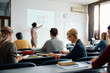 © Drazen - Smiling mature woman takes notes during education training class.