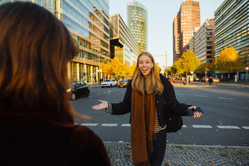 Excited woman enjoying meeting her friend at city street