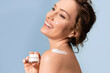 © deniskomarov - A happy laughing woman is taking care of her skin and holding a jar of cream in her hands