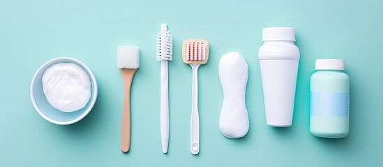 Wall Mural - dental hygiene kit on a blue background with a toothbrush, electric toothbrush, tongue cleaner, floss, toothpaste tube, and mouthwash. This flat lay composition represents dentist concepts