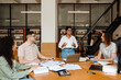 © Drobot Dean - Group of students having discussion while studying together in library